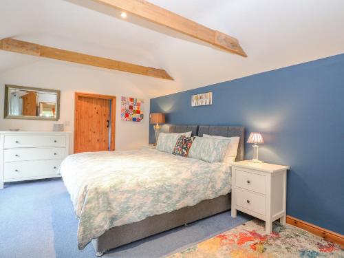 een slaapkamer met een groot bed en een blauwe muur bij The Lodge in Norwich