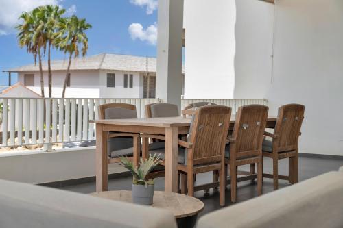a wooden table and chairs on a balcony at Grand Windsock Bonaire in Kralendijk
