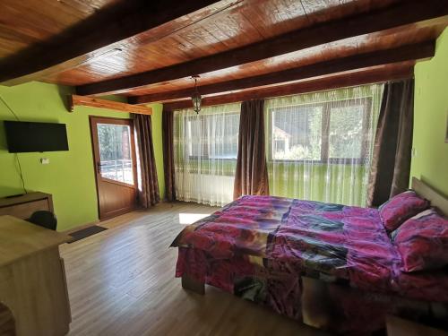 a bedroom with a bed in a room with windows at Casa LUCA in Luncasprie