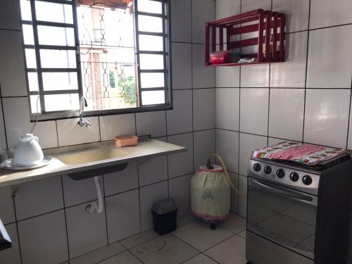 a kitchen with a stove and a sink and a window at Espaço Magalhães in Barra do Garças
