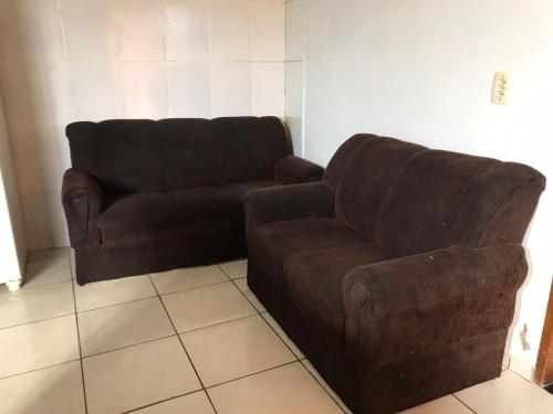 a brown couch and a chair in a living room at Espaço Magalhães in Barra do Garças