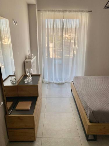 a bedroom with a bed and a dresser and a window at Eleusis Luxury Flat,car park in property in Elefsina