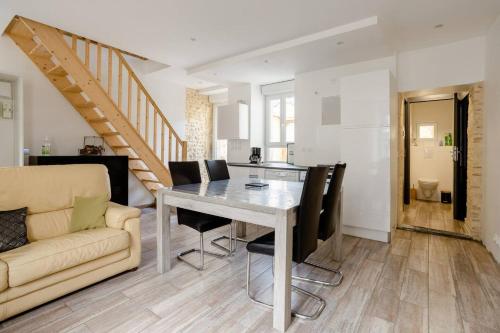 une cuisine et une salle à manger avec une table et des chaises dans l'établissement Maison accueillante à Noyen-sur-Sarthe avec terrasse, à Noyen-sur-Sarthe