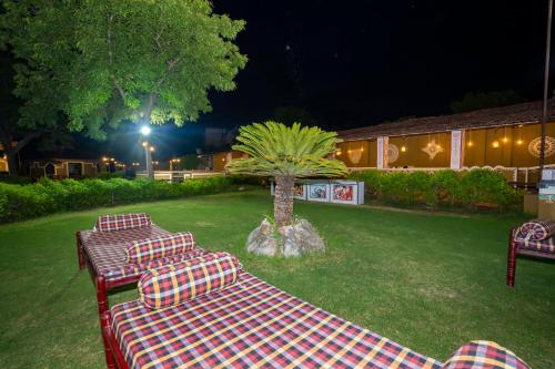 a group of picnic tables in a yard at night at Swad Ri Dhani, Ajmer in Ajmer