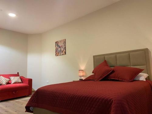 a bedroom with a red bed and a red chair at Americas Apartment in Sucre