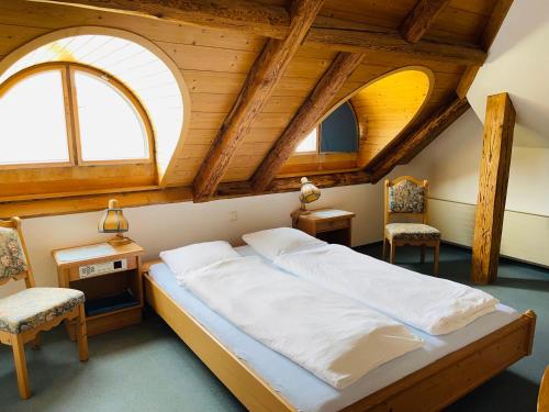 a bedroom with a large bed with two windows at Hotel Sternen Worb in Worb