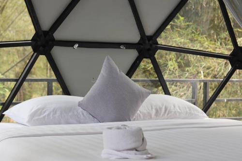 a bed with a white pillow and a window at Adventure Dome Resort in Kep