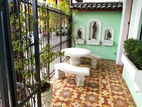 eine Terrasse mit einem weißen Tisch und einer Bank neben einem Tor in der Unterkunft Casa del Agua in Granada