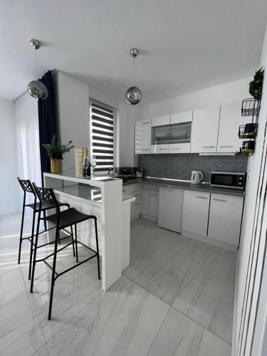 a kitchen with white cabinets and a table and chairs at MY PLACE in Slavonski Brod