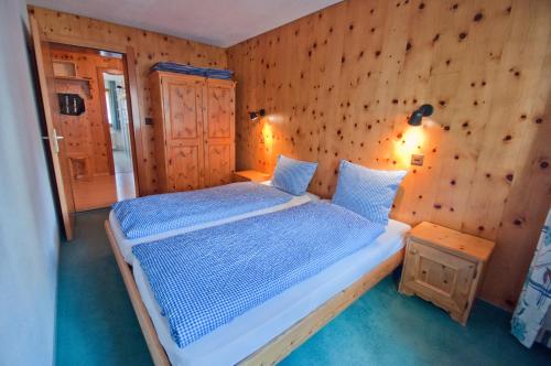 a bedroom with a bed in a wooden wall at Dent Blanche in Zermatt