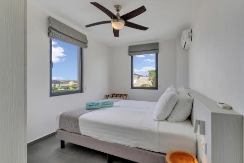 a bedroom with a bed with a ceiling fan at Grand Windsock Bonaire in Kralendijk