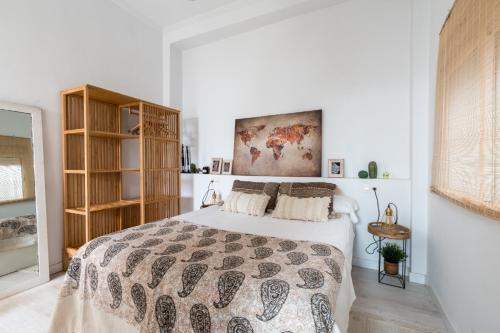 um quarto com uma cama e uma estante de livros em Oasis con patio y encanto en centro Sevilla em Sevilha