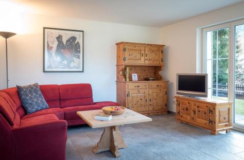 a living room with a red couch and a tv at Haus Wick in Klosters Serneus