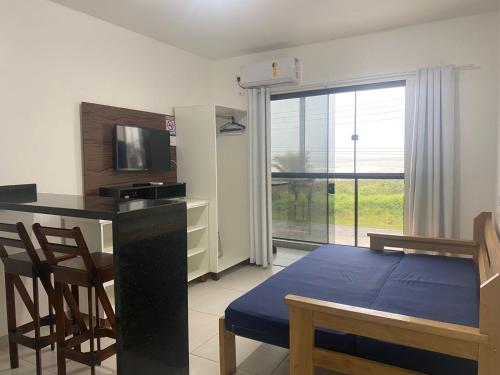 a room with a bed and a desk with a television at Condominio Boa Vista in Pontal do Paraná