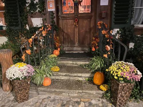 a front door with pumpkins and flowers on the steps at Hotel Sternen Worb in Worb