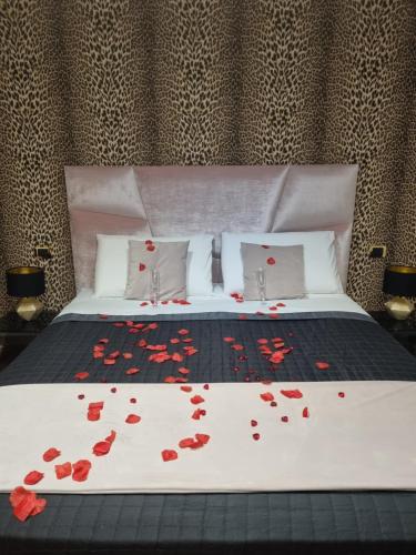 a bed with red rose petals on it at B&B The View all'Acquedotto in Rome