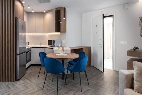a kitchen and dining room with a table and blue chairs at ANIMA DEL SOL (BASILICO) in Ixia