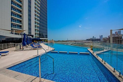 una gran piscina de agua azul en un edificio en Exquisite Apartment Minutes Away from the Beach, en Dubái
