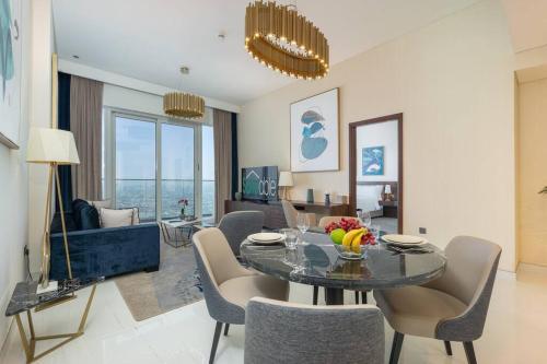ein Wohnzimmer mit einem Esstisch und Stühlen in der Unterkunft Exquisite Apartment Minutes Away from the Beach in Dubai