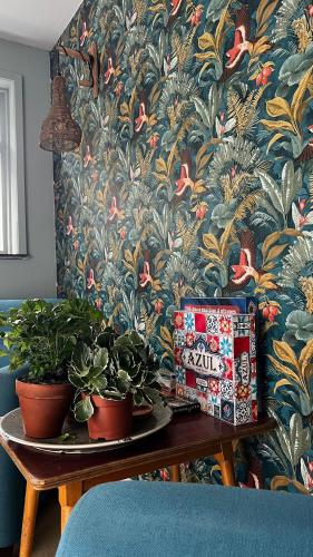 a table with potted plants on it with a wallpaper at Boetiek hotel Azul in Goedereede