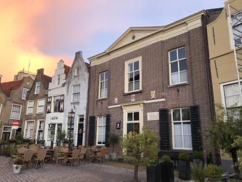 a row of buildings on a street with tables and chairs at Boetiek hotel Azul in Goedereede