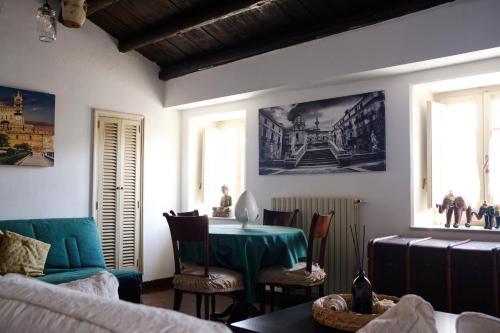 uma sala de estar com uma mesa verde e cadeiras em Attico con terrazza sul porto em Palermo