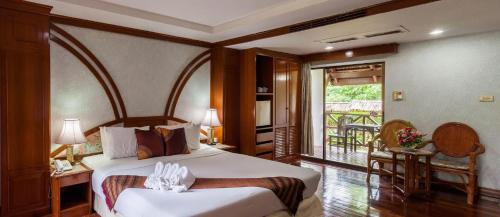 a hotel room with a bed and a balcony at Royal Ping Garden and Resort in Mae Taeng