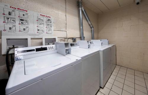 a row of white washing machines in a room at HomeTowne Studios by Red Roof Bordentown - McGuire AFB in Bordentown