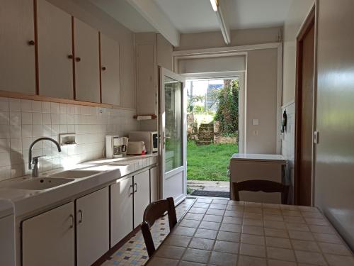 una cucina con lavandino e una porta per un cortile di Maison Cancale Port-Mer a Cancale