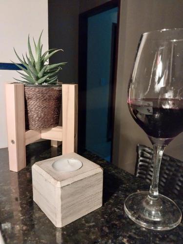 a glass of wine sitting on a table with a wooden box at Casa Aconchegante em Areia in Areia