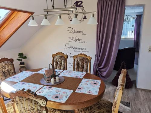 a dining room table and chairs with a sign on the wall at Ländliche Idylle in Hochfranken in Regnitzlosau