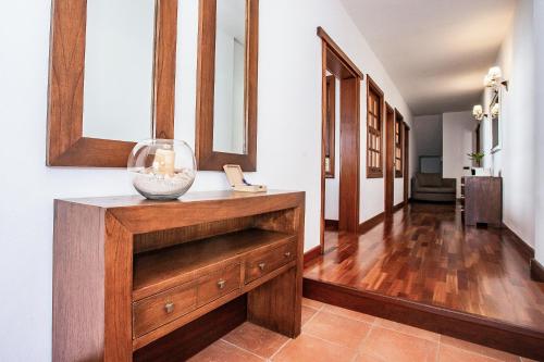 un pasillo con un tocador de madera con un jarrón. en Guanapay Home en el Centro de Teguise en Teguise