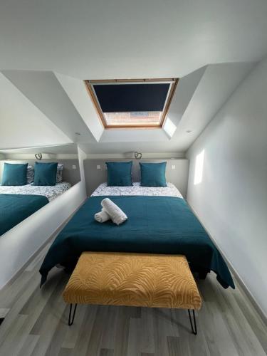 1 dormitorio con 1 cama grande con almohadas azules en Résidence Tamaris Soline, en Lanvallay