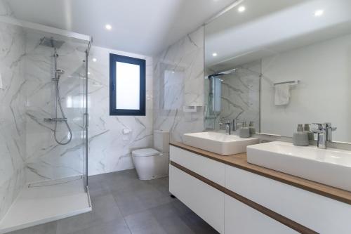 La salle de bains est pourvue de 2 lavabos et d'une douche. dans l'établissement Oasis 325 Ground Floor, à Estepona