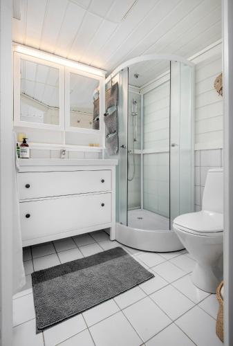 a white bathroom with a shower and a toilet at Økslevegen 2 in Stranda