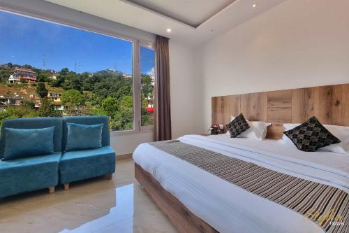 Moon Glade By Stylia Hotels في دالهوزي: غرفة نوم مع نافذة كبيرة وسرير وكرسي أزرق