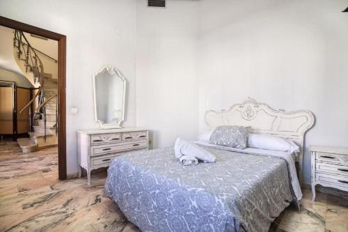 1 dormitorio con cama, tocador y espejo en Palacete del Porvenir en Sevilla