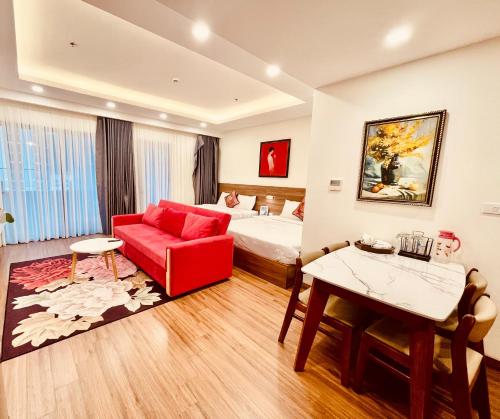 a hotel room with a bed and a red couch at FLC SEA TOWER - 4 SEASONS Apartment in Quy Nhon