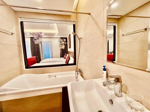 a bathroom with a sink and a large mirror at FLC SEA TOWER - 4 SEASONS Apartment in Quy Nhon