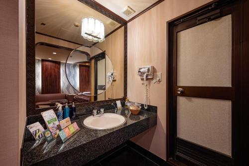 a bathroom with a sink and a large mirror at Hotel Metro (Adult Only) in Yokohama