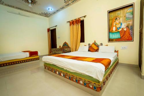 a bedroom with a bed and a painting on the wall at Swad Ri Dhani, Ajmer in Ajmer