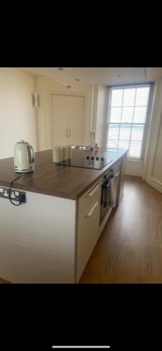 a kitchen with a sink and a counter top at Caldey View- a beautiful flat in the heart ofTenby in Tenby