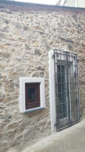 a window with bars on a stone building at La pietra di Sersa in Quaratica