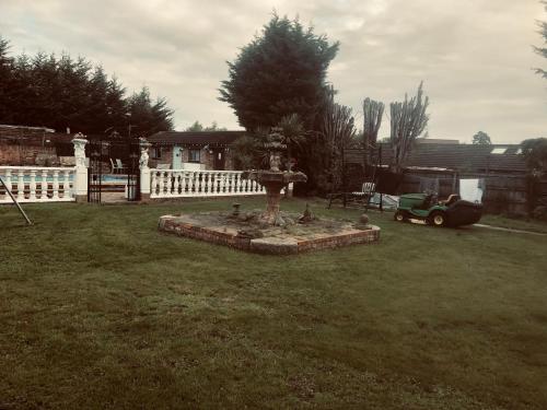 a yard with a bird bath in the grass at Tudor House - Double Room - Shared Bathroom in Goffs Oak