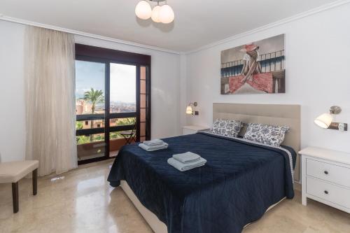 una camera con letto e copriletto blu di El Soto de Marbella a Marbella