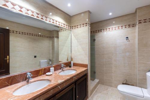 un bagno con due lavandini e un grande specchio di El Soto de Marbella a Marbella