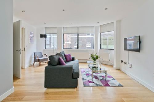 a living room with a couch and a table at Red Lion Court by City2Stay in London