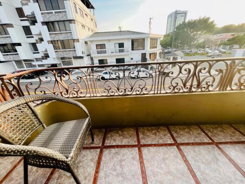 balcón con silla y vistas a la ciudad en Junior Suite a few minutes from shopping centers and airport, en Guayaquil