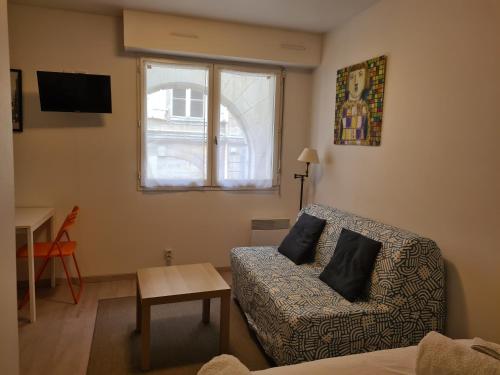 a living room with a couch and a window at Studio centre de Bordeaux in Bordeaux