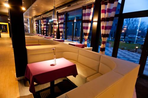a row of couches in a restaurant with a red table at Hotel Malinowski Business in Gliwice